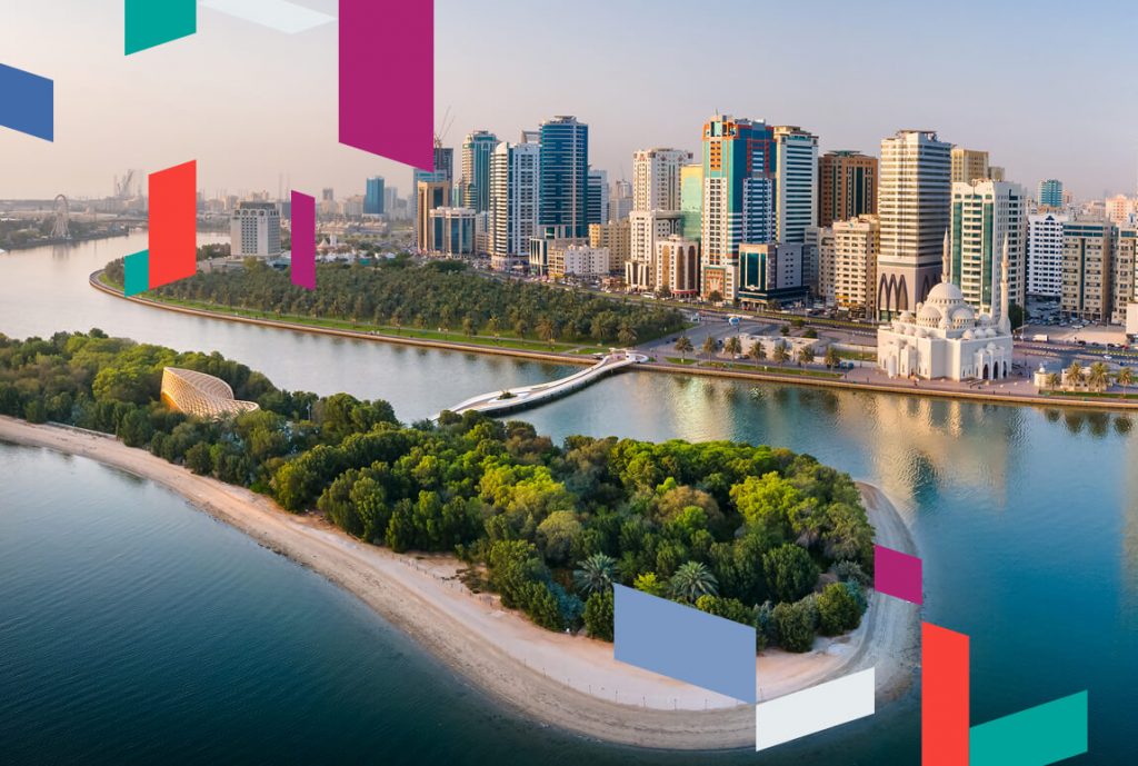 Aerial view of Sharjah cityscape with colorful geometric overlays.