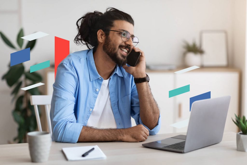 Person on phone at desk with laptop related to business setup in UAE.