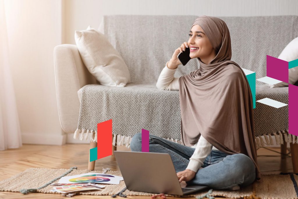Smiling woman working on laptop and phone, representing SPC Free Zone business setup.