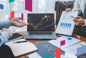 Discussion on business trends with charts and laptop in Sharjah free zone office.