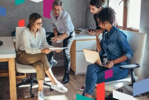 Four people in a modern office setting discussing business documents.