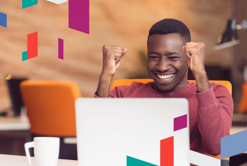 Happy man celebrating in office with colorful geometric design.