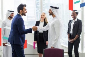 Business professionals shaking hands in a UAE office.