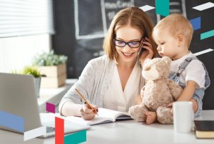 Businesswoman in office with child, discussing UAE free zone company setup.