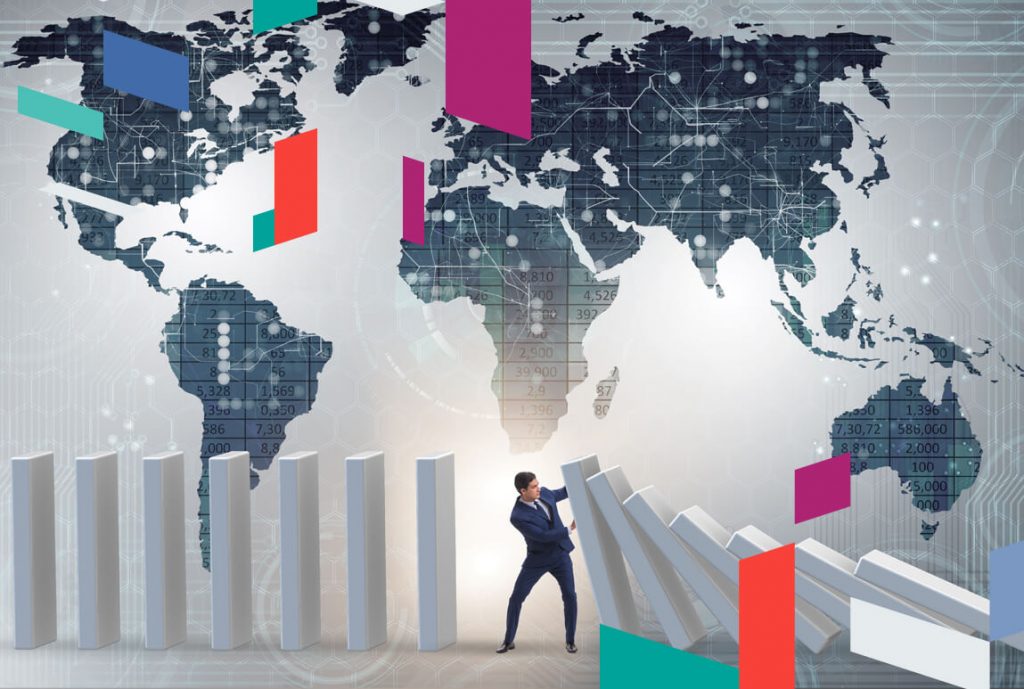 Businessman stopping falling blocks with a world map background.