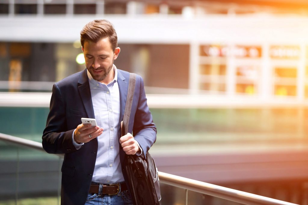 Businessman using smartphone in a modern office environment.