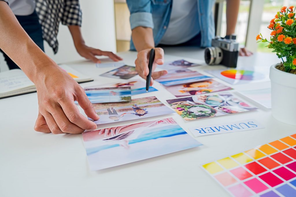Team planning over photographs and color swatches on a desk.