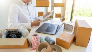 Person managing business logistics with packages on a desk.