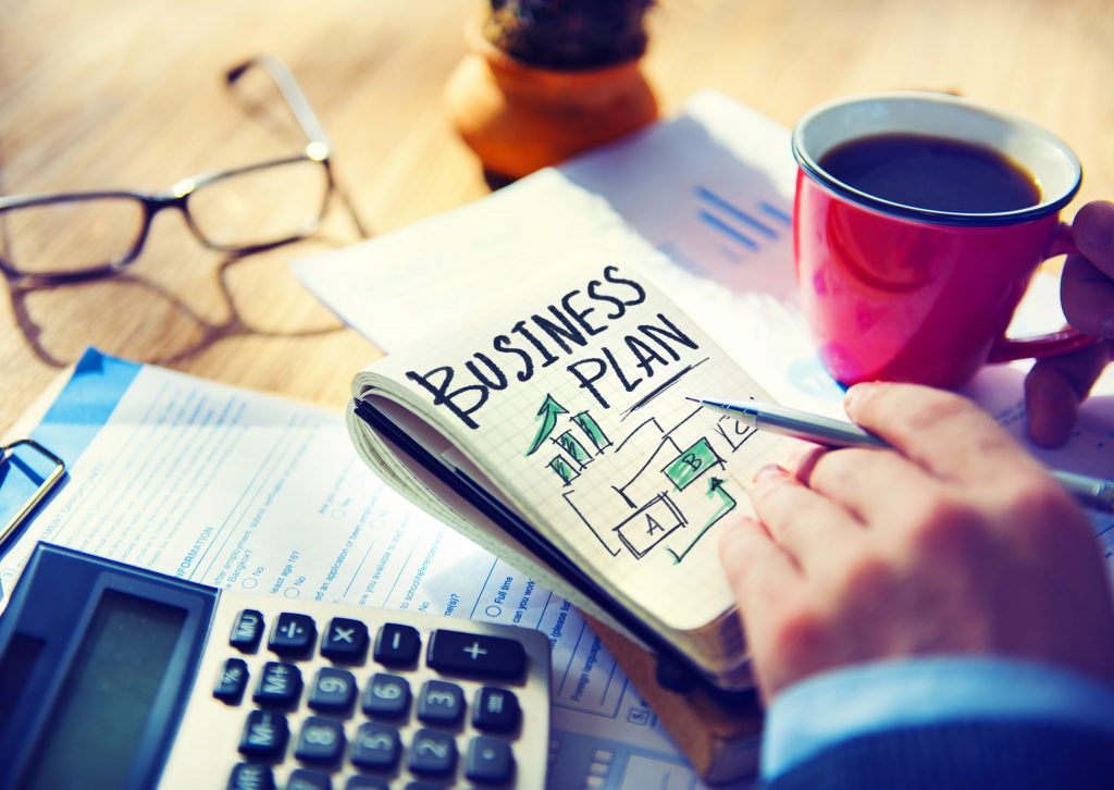 Person planning business setup in UAE with documents and coffee.