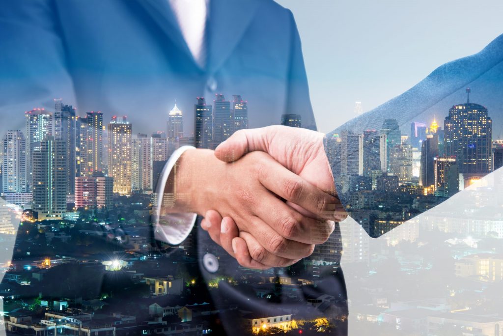 Business handshake with cityscape backdrop symbolizing UAE business setup.