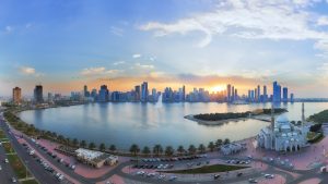 Sharjah skyline at sunset with business district view.