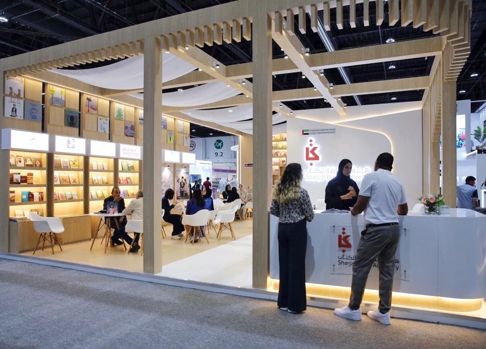 Exhibition booth featuring SPC Free Zone in Sharjah with business representatives and visitors.