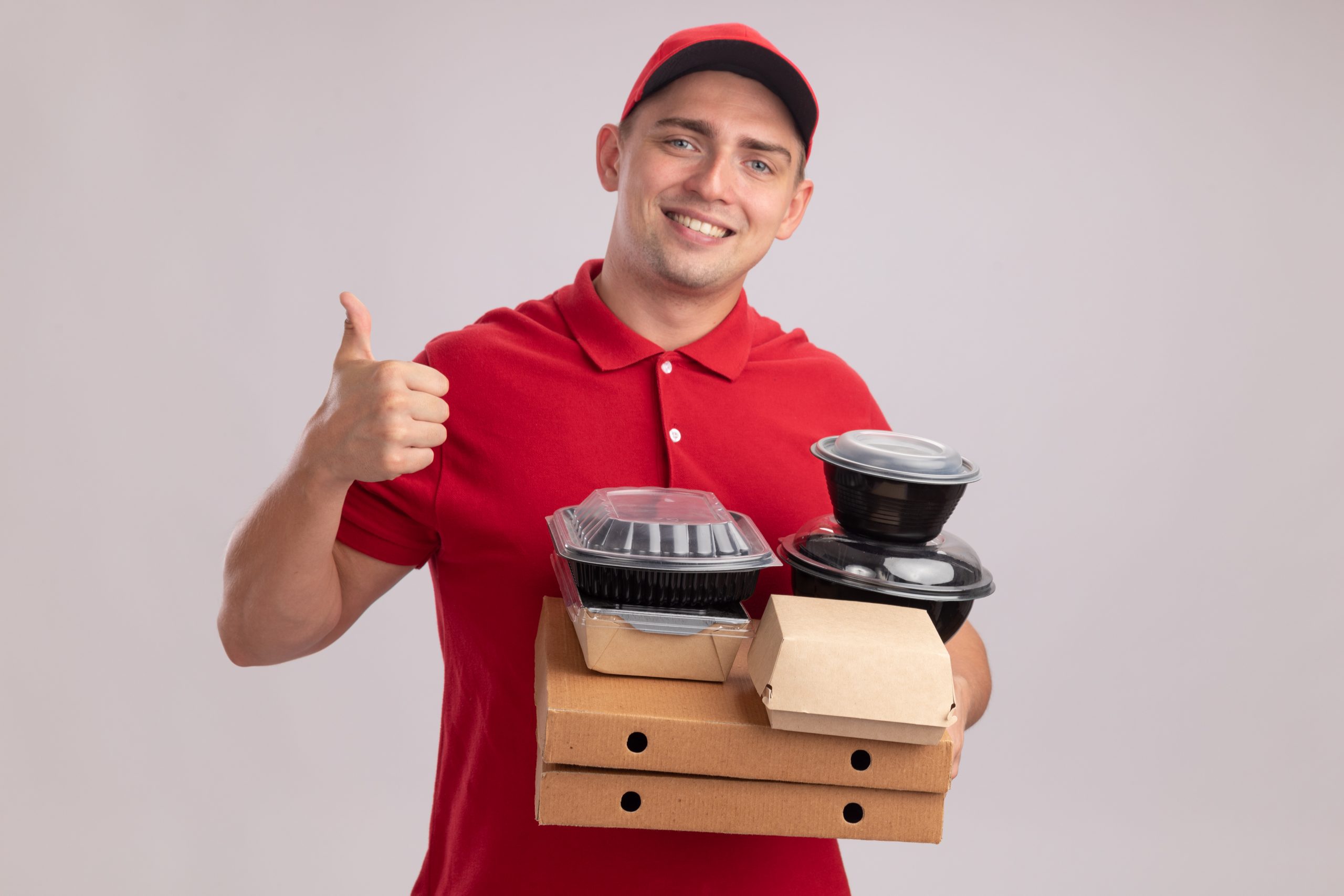 Smiling delivery person holding food containers and giving a thumbs-up.