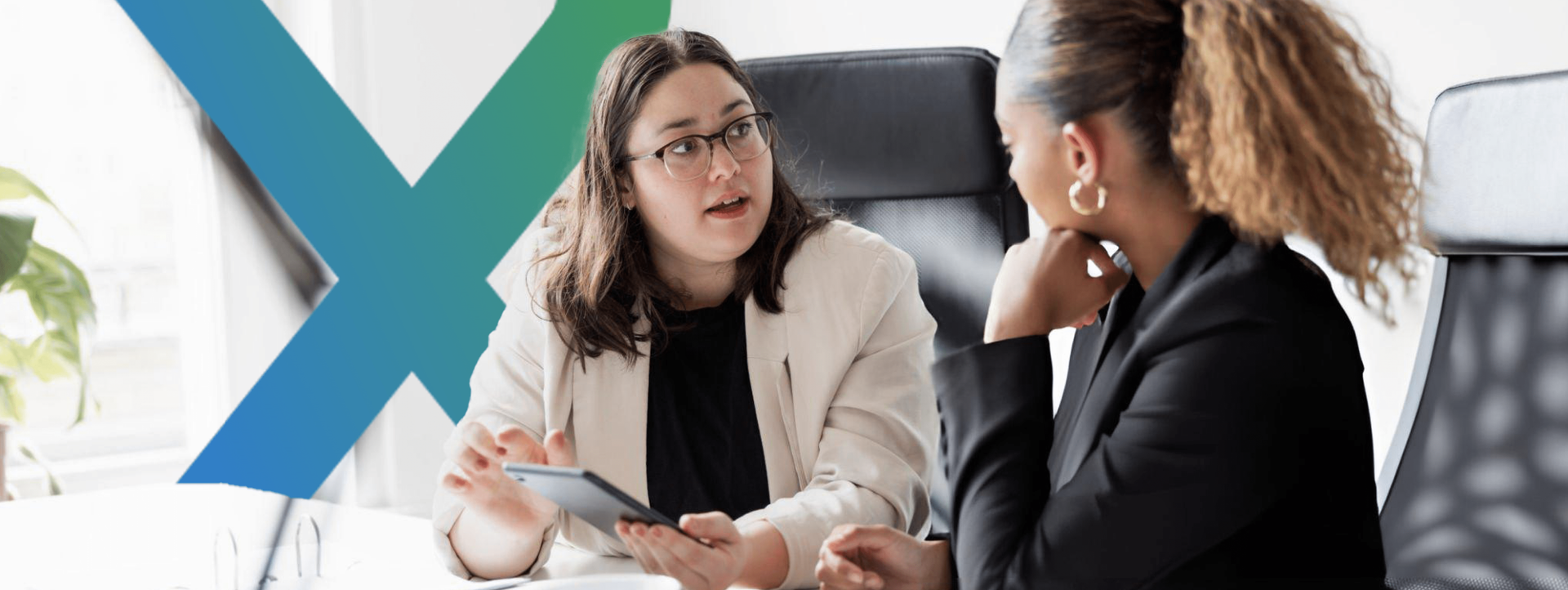 Two women discussing business setup in UAE at an office.