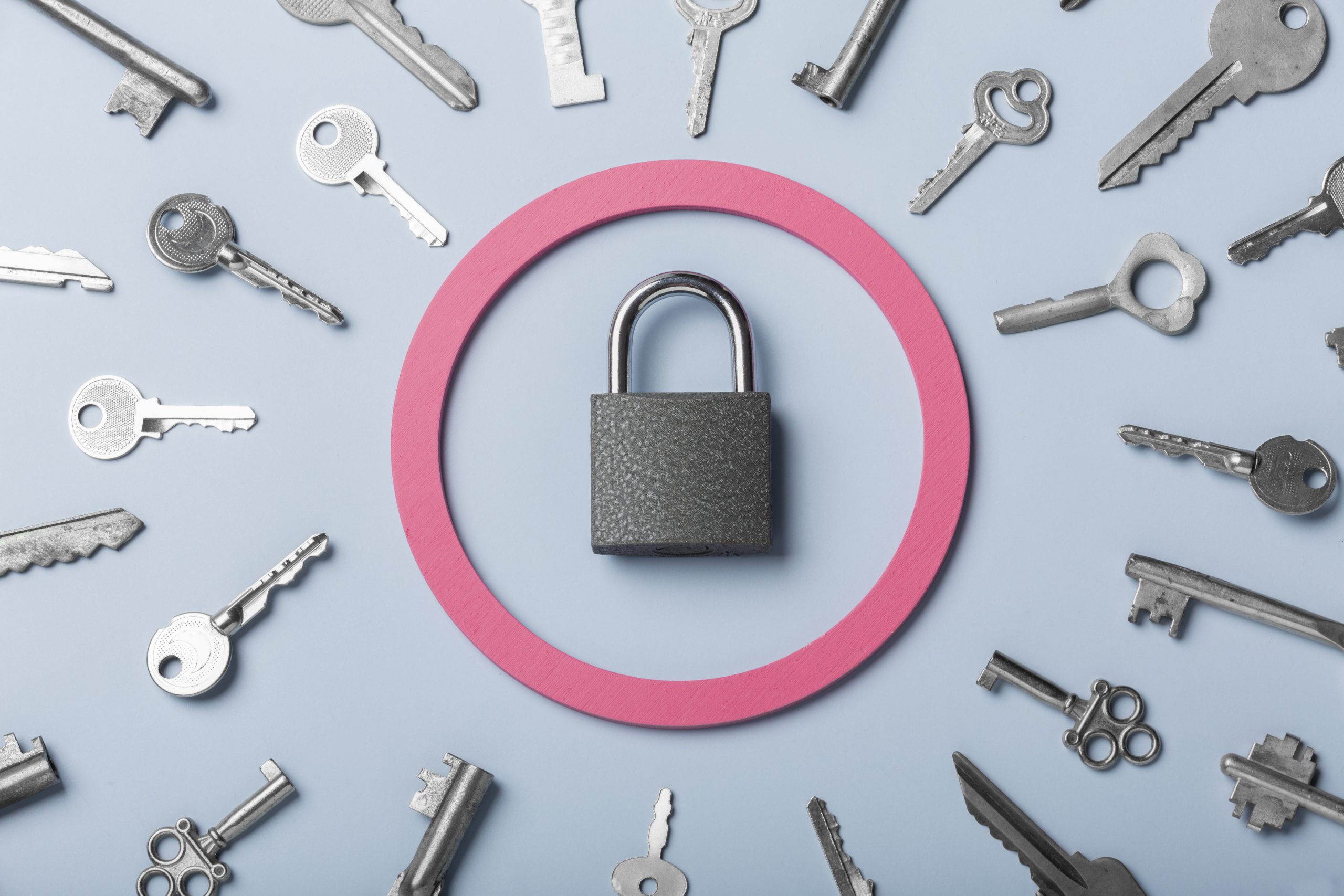 Padlock surrounded by keys within a pink circle.
