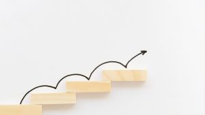 Wooden blocks symbolizing business growth with upward arrow.