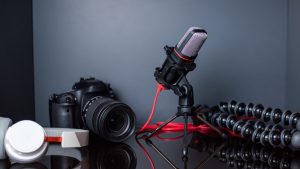 Microphone, camera, and accessories on a reflective surface.